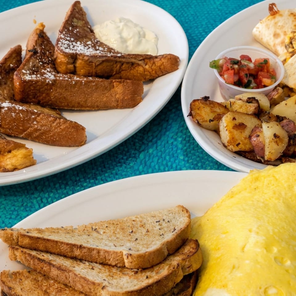 Three plates display powdered French toast, breakfast burritos with roasted potatoes and salsa, and a golden omelet with toast.